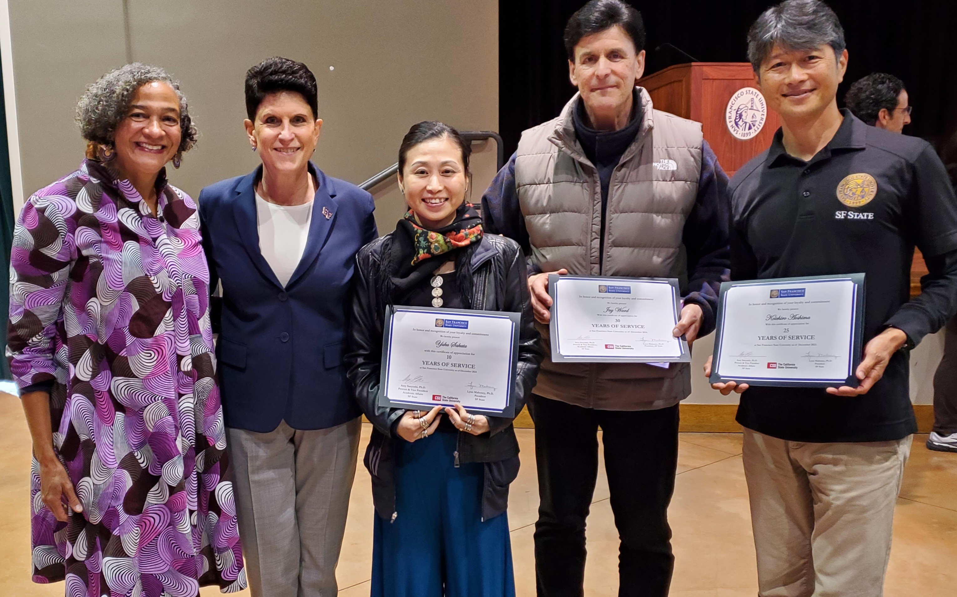4 employees posing with the university president